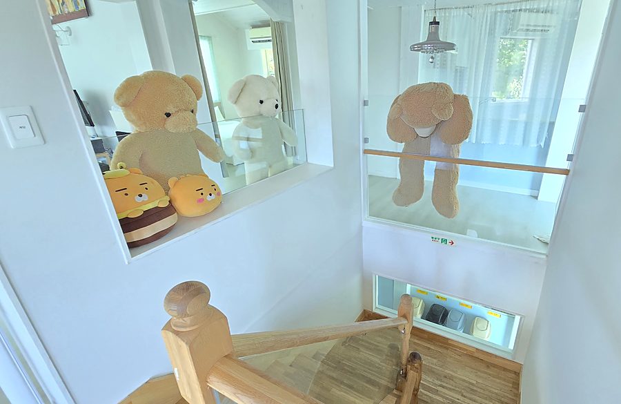 계단 난간에 걸터앉은 커다란 곰 인형들